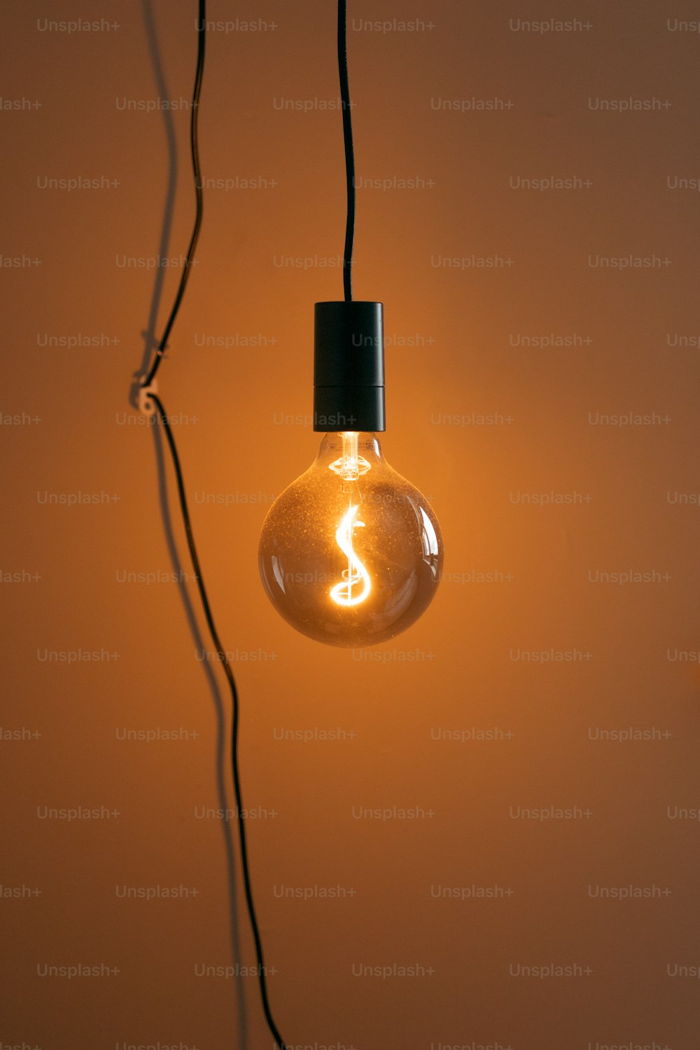 a light bulb with a black cord hanging from it