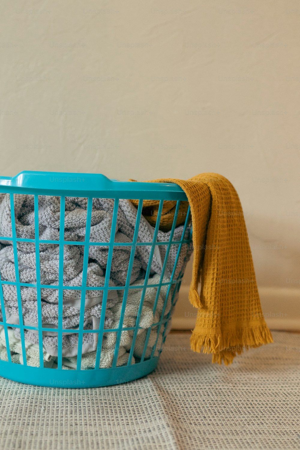 a blue basket filled with blankets on top of a table