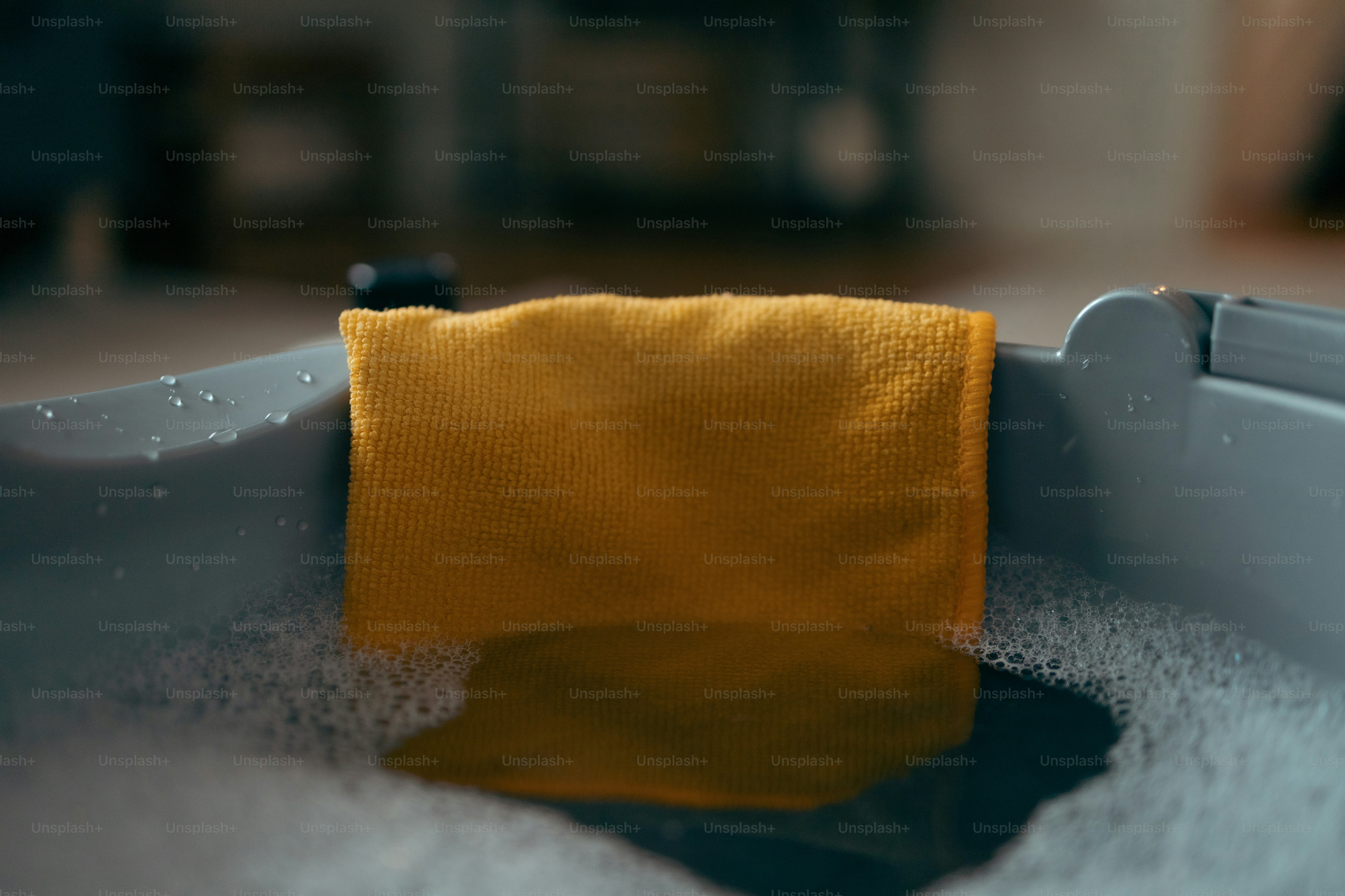 a yellow towel sitting in a bathtub filled with water