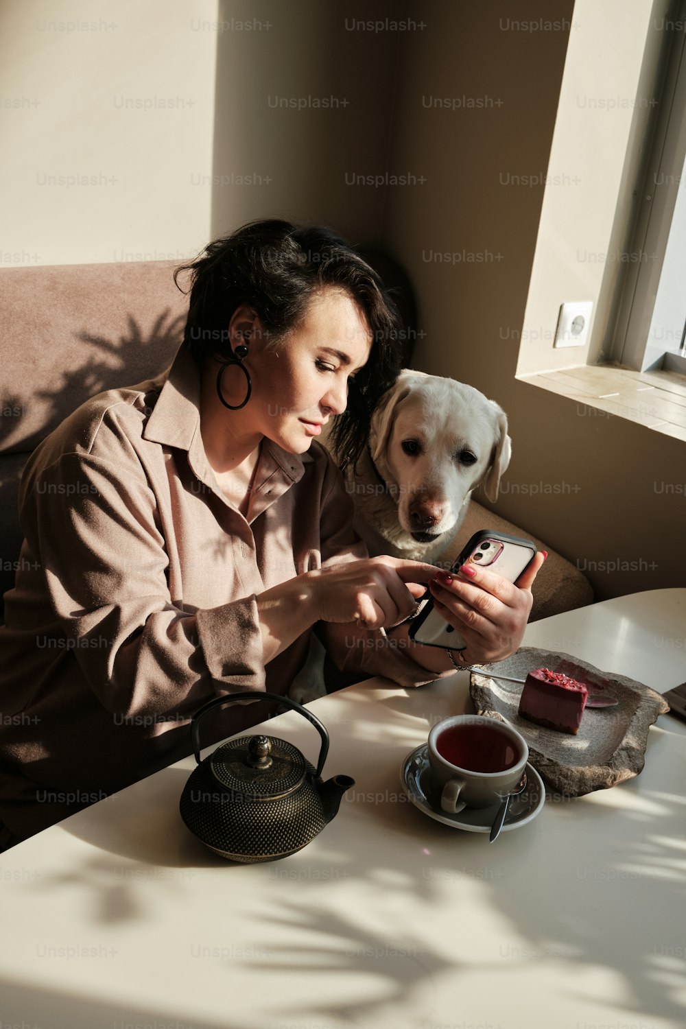 a woman sitting at a table with a dog