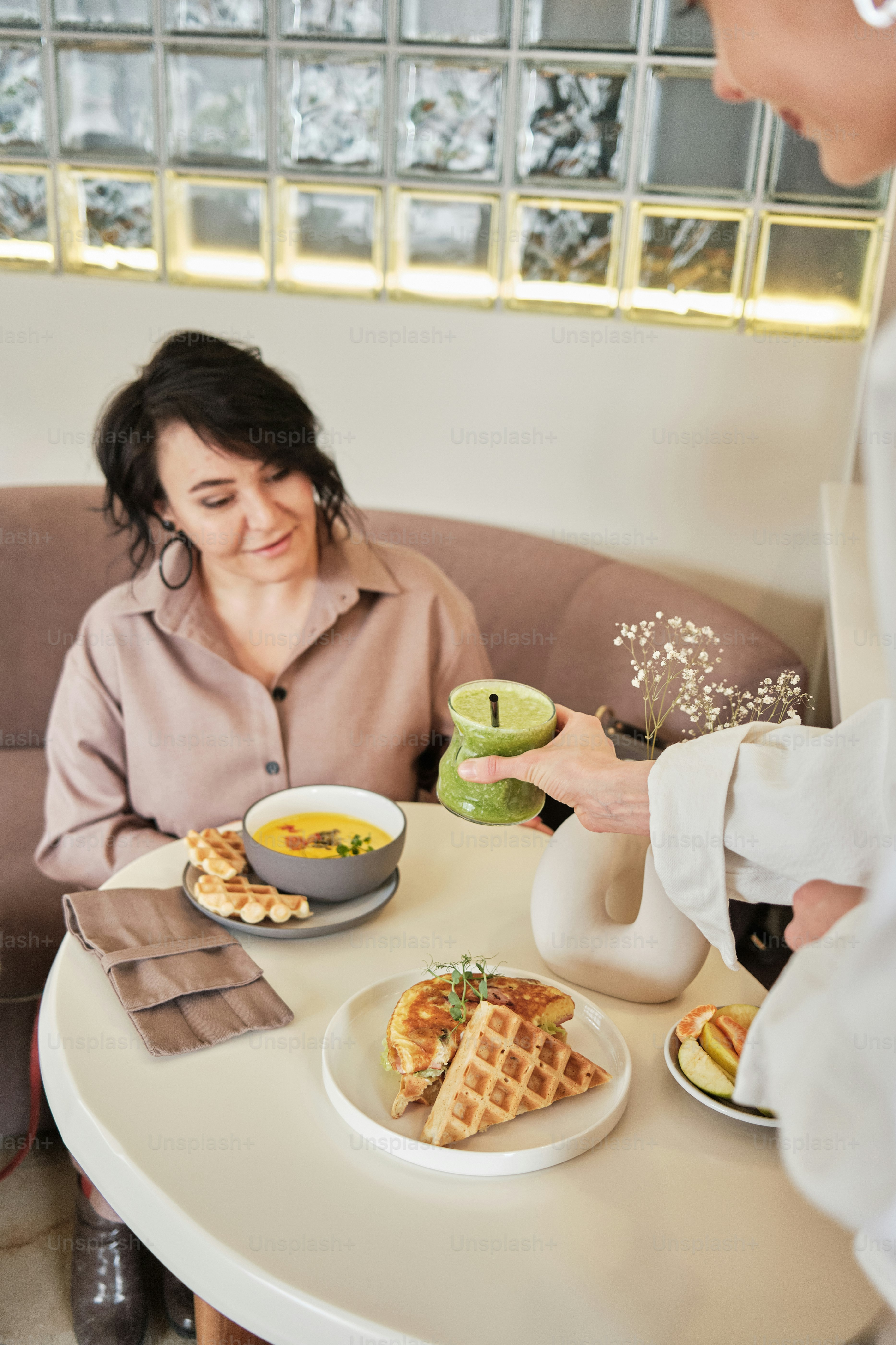 a woman sitting at a table with a plate of food