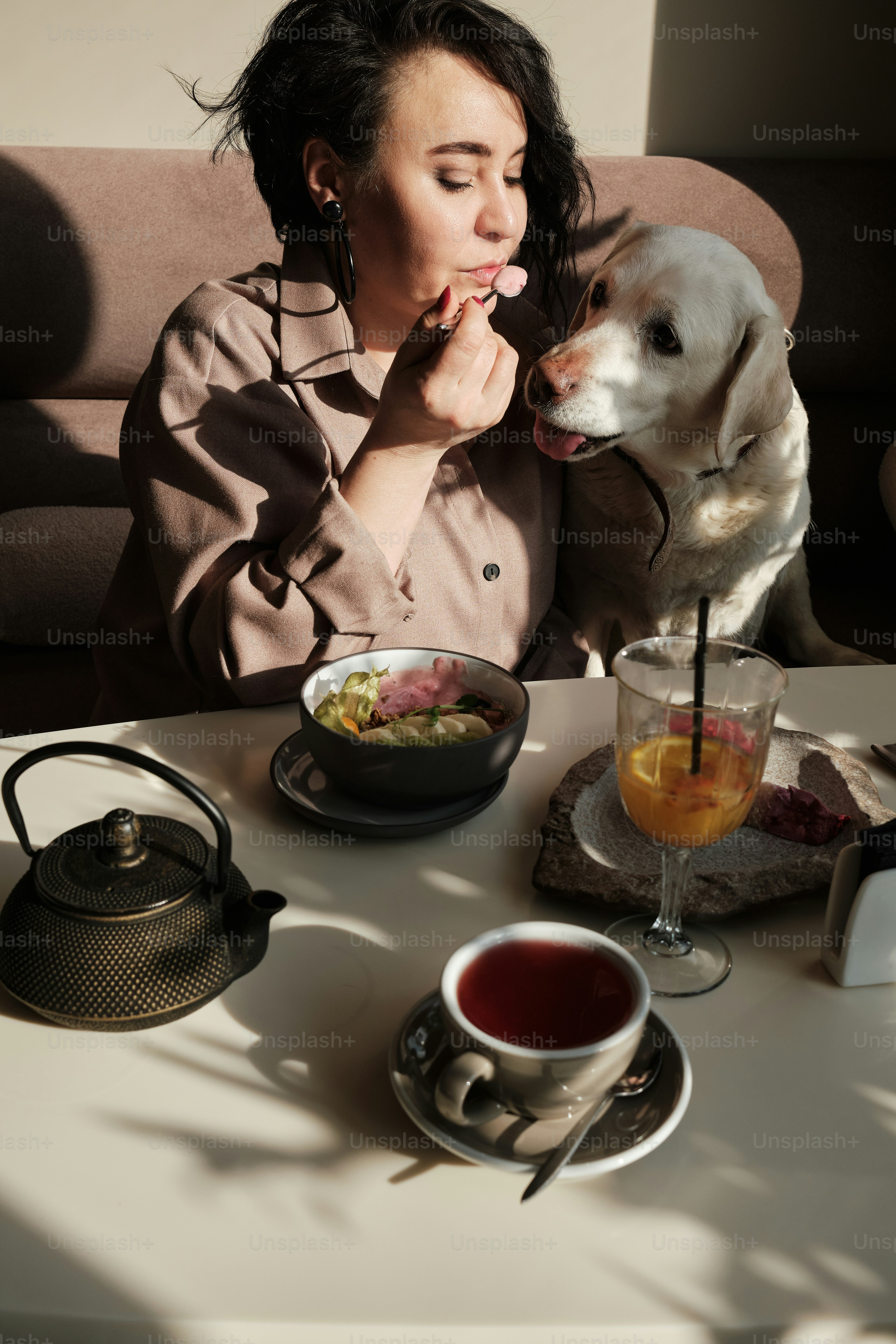 a woman sitting at a table with a dog