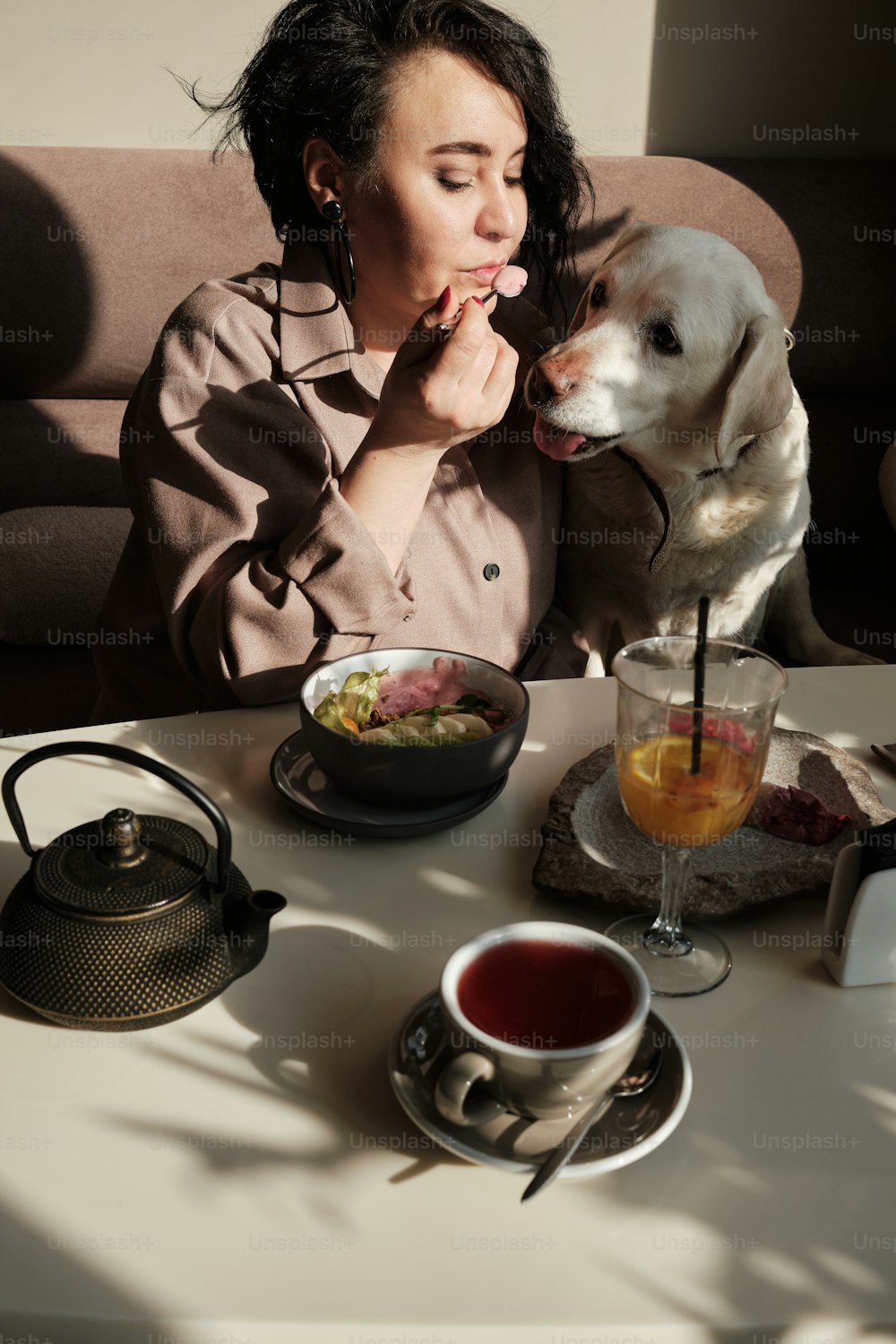 una donna seduta a un tavolo con un cane