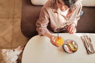Eine Frau sitzt an einem Tisch mit einer Schüssel mit Essen