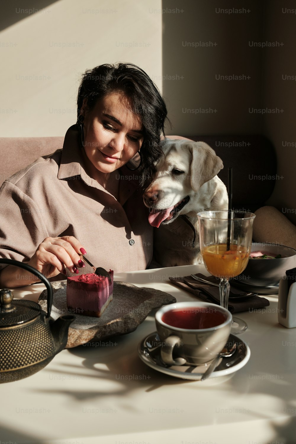 Una mujer sentada en una mesa con un perro