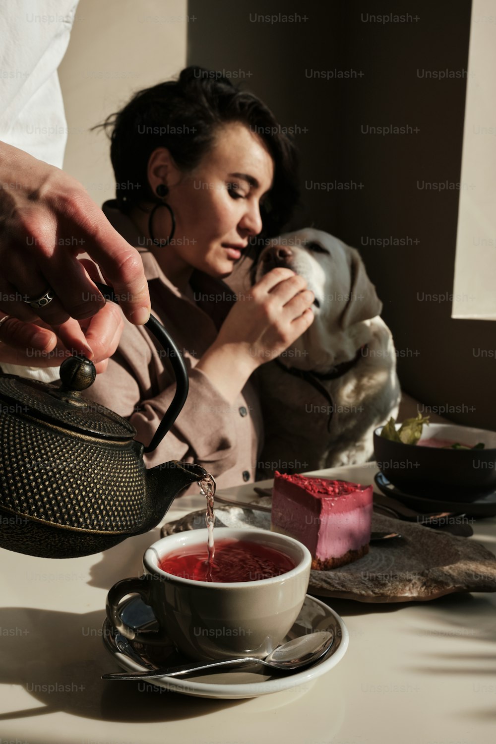 Une femme verse du thé dans une tasse