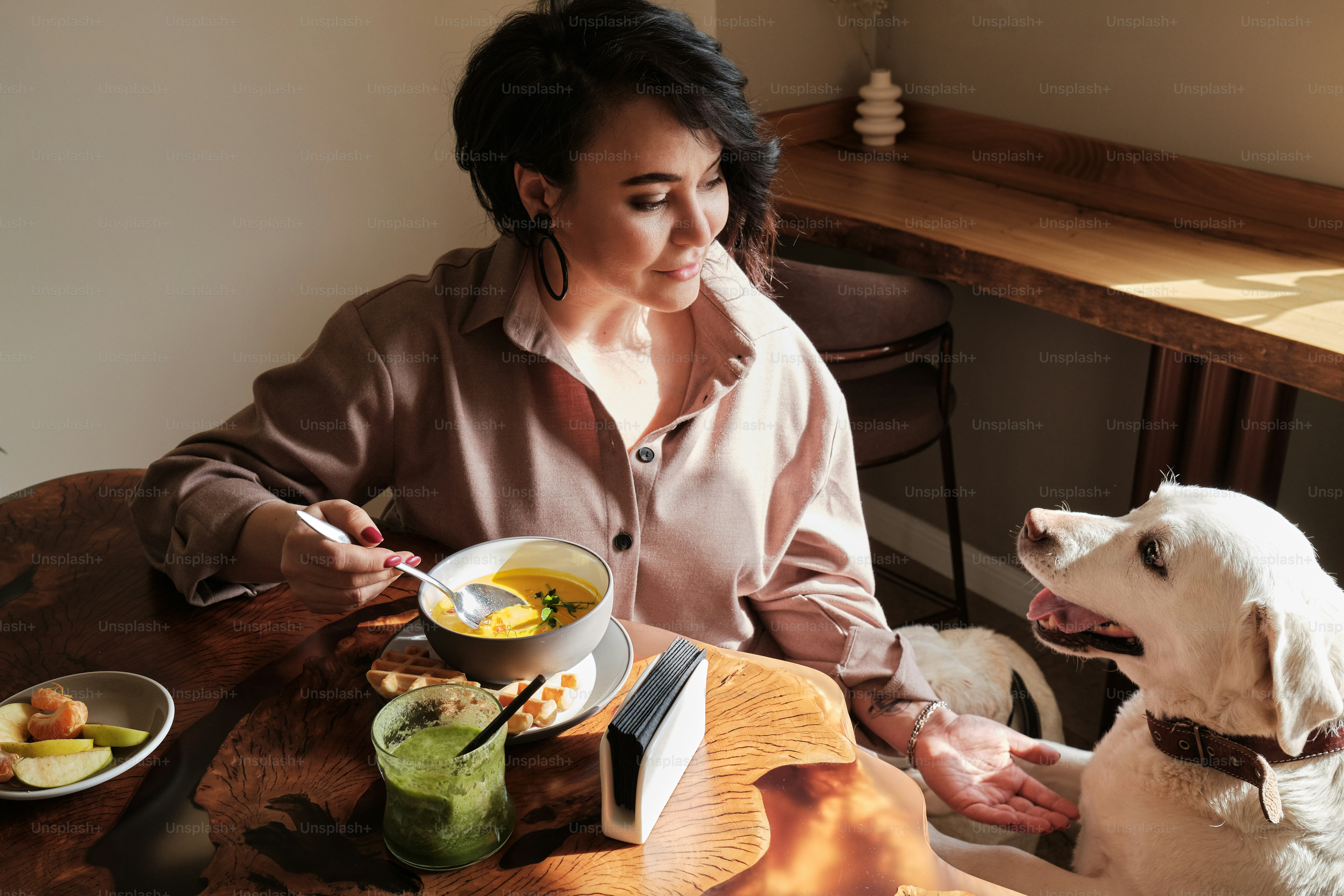 a woman sitting at a table with a dog