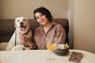 a woman sitting at a table with a dog