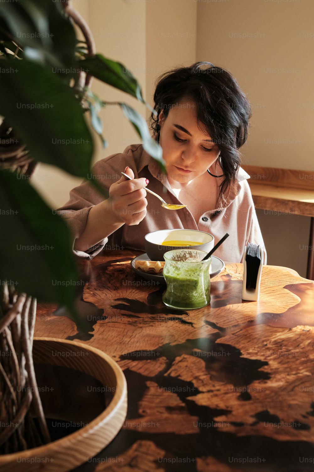 Una mujer sentada en una mesa comiendo alimentos