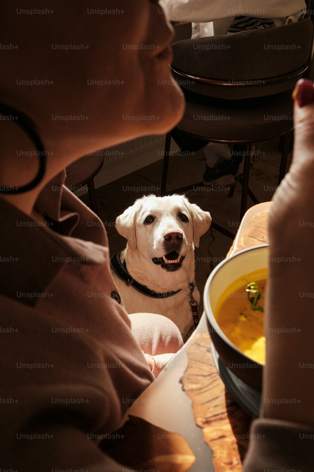 Una mujer sentada en una mesa con un plato de sopa frente a ella