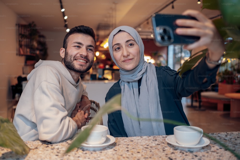 um homem e uma mulher tirando uma foto com uma câmera