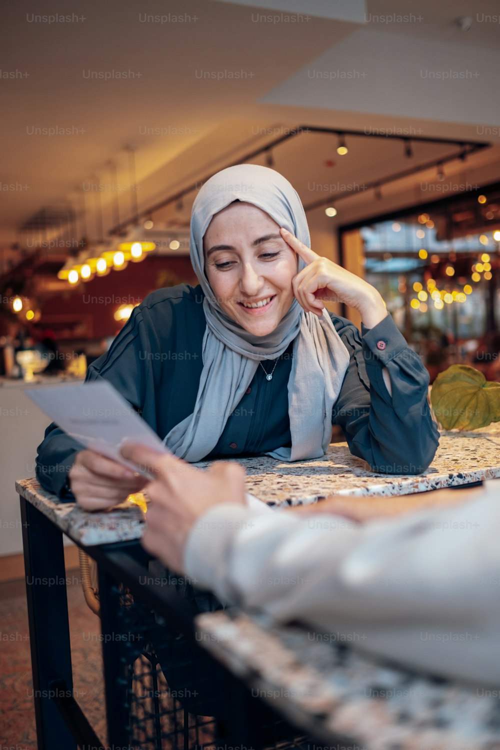 a woman in a headscarf sitting at a table