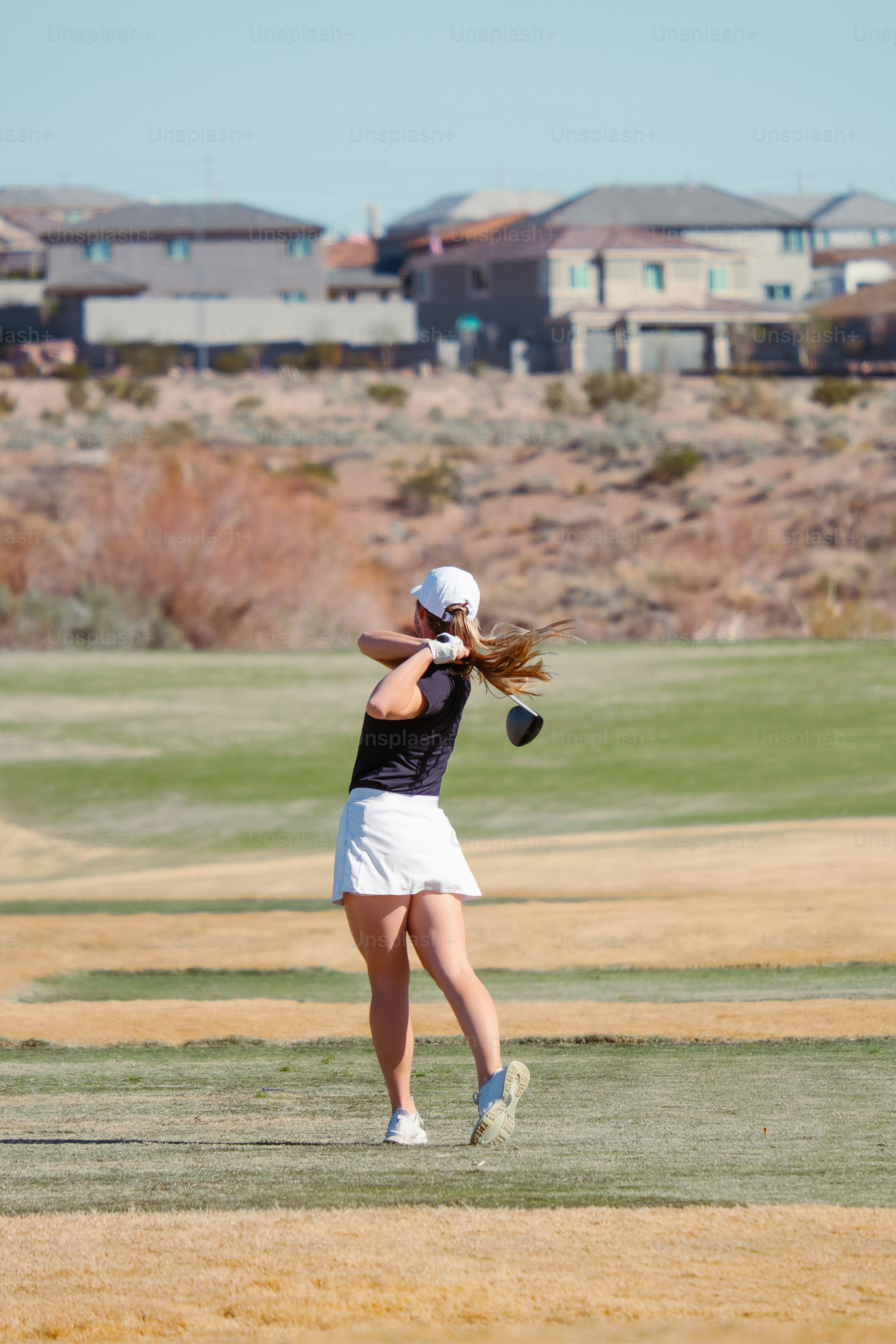 フィールドの上にテニスラケットを振る女性