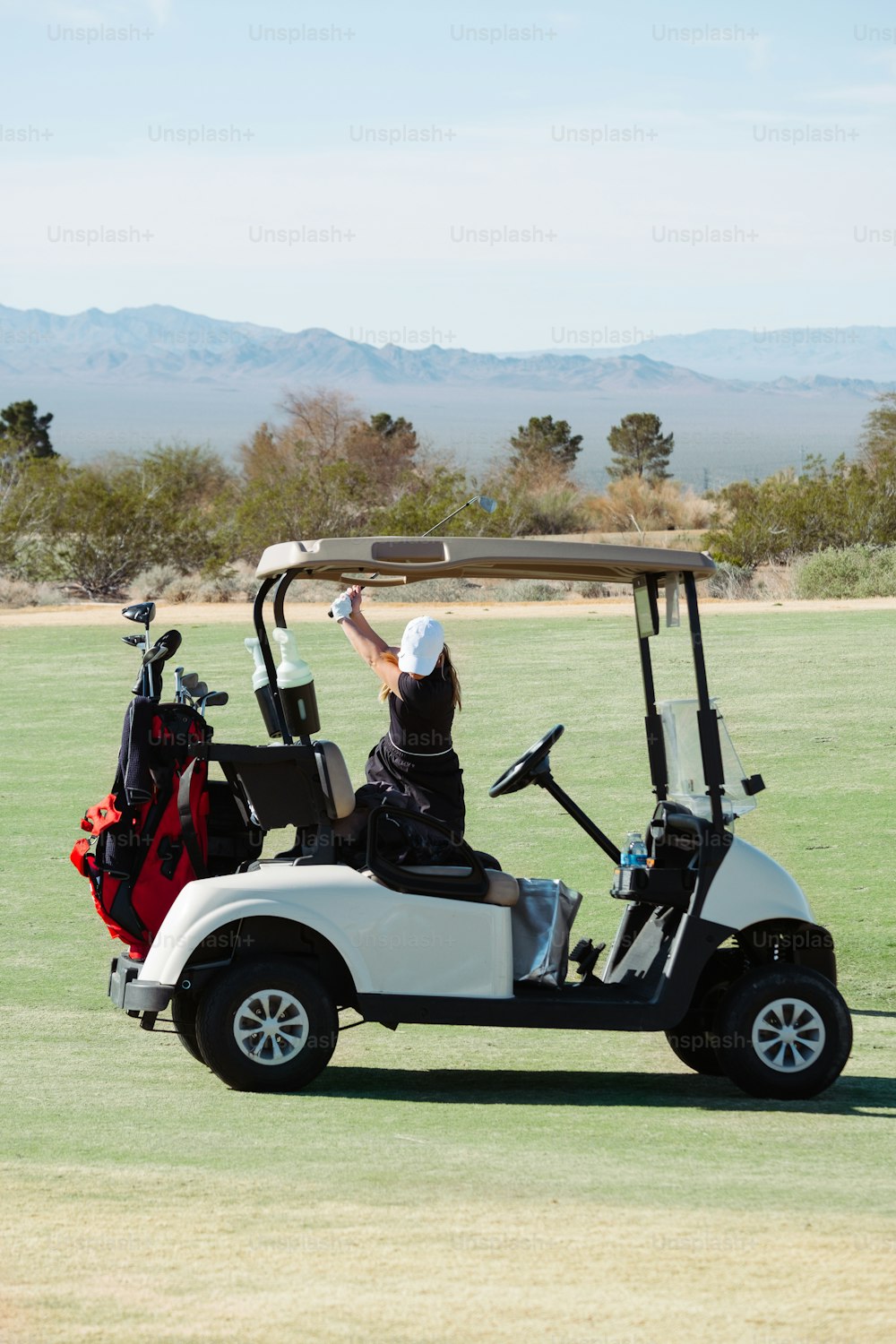 a person riding a golf cart in a field