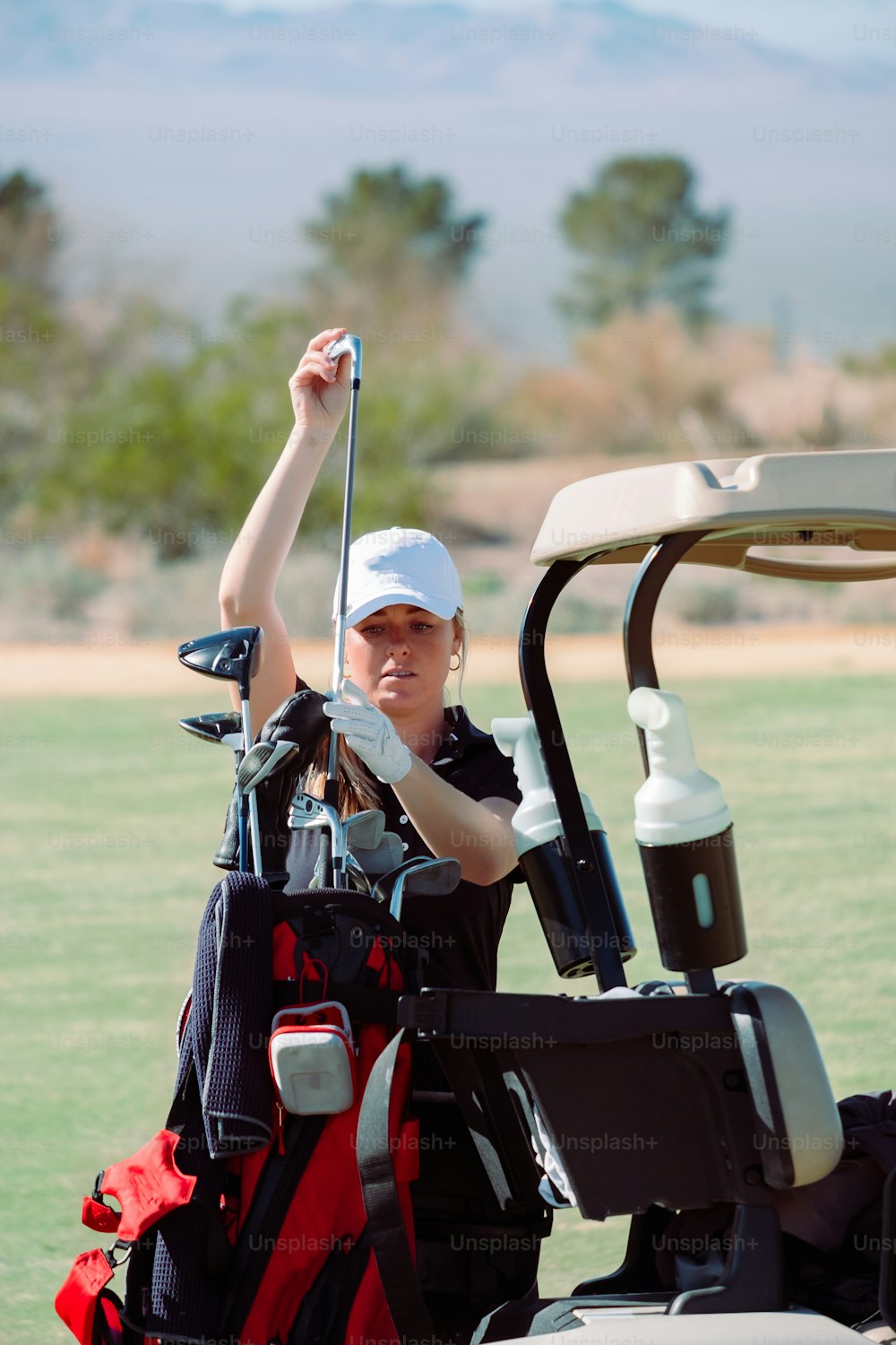 a woman in a golf cart holding a golf club