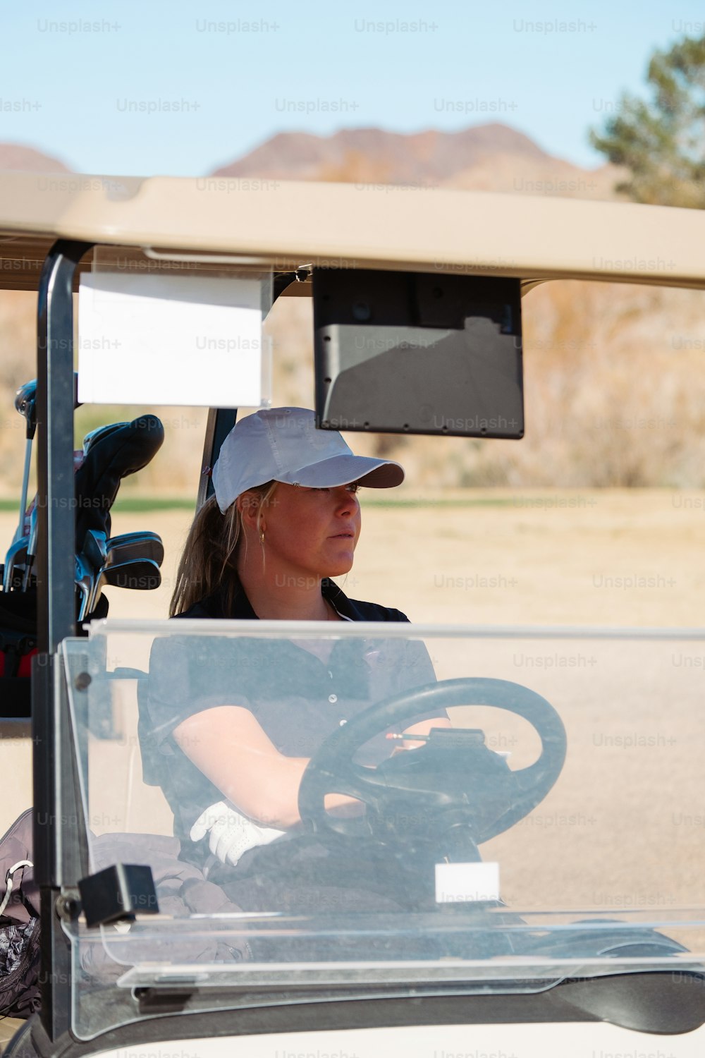 a woman driving a golf cart with a driver