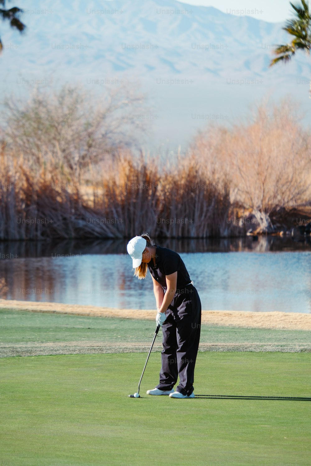 a woman putting a golf ball on the green