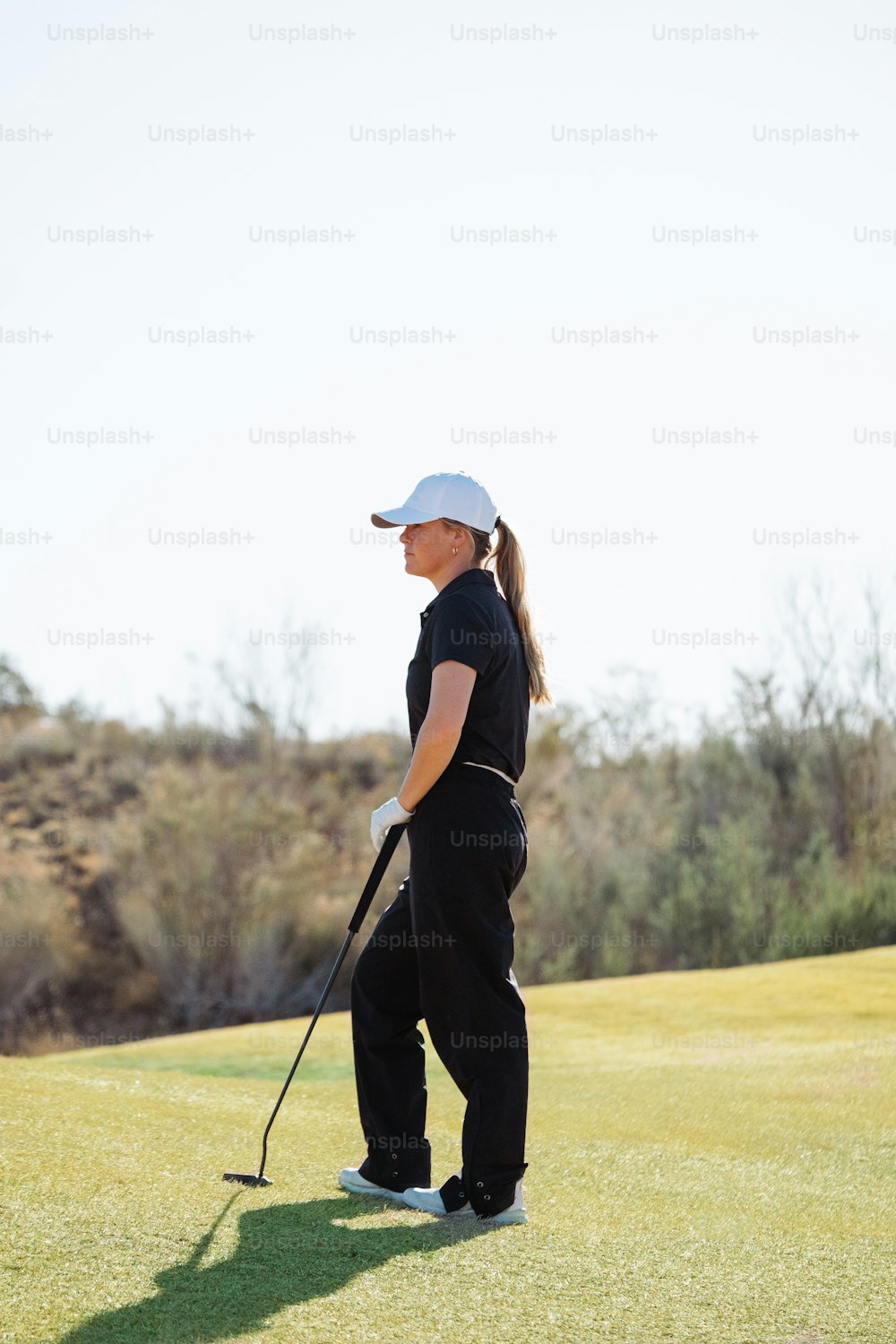 a woman standing on top of a green golf field