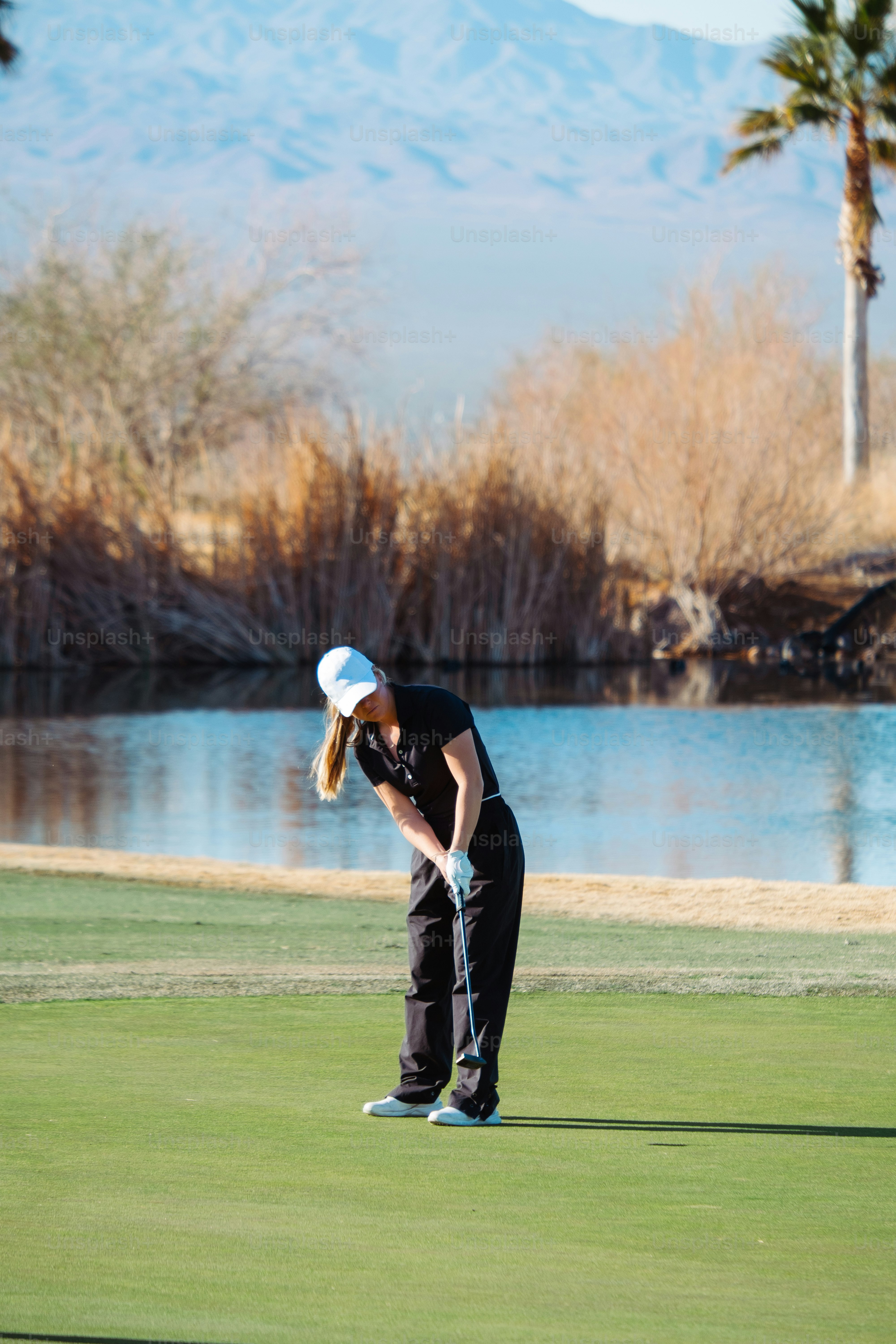 緑のゴルフ場の上に立つ女性