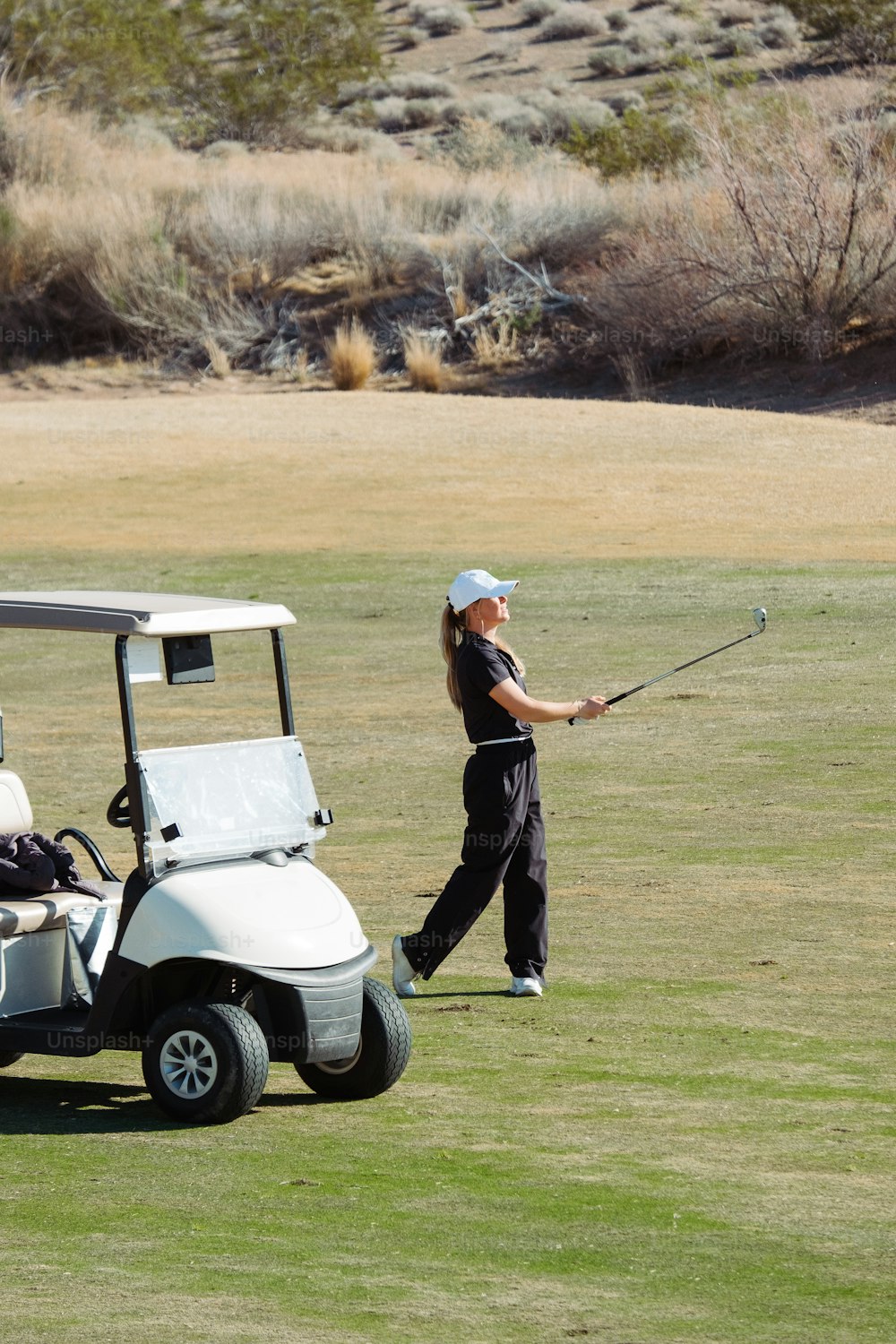 a woman playing golf on a golf course
