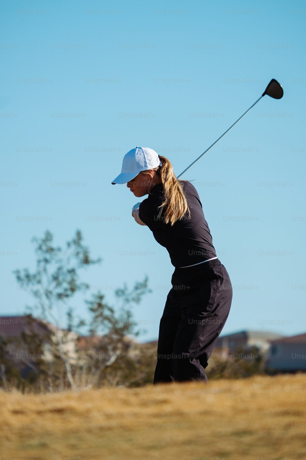 a woman swinging a golf club on a golf course