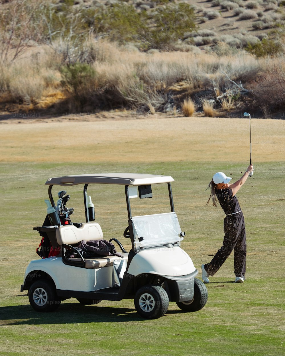 une personne sur un terrain de golf balançant un club de golf