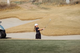 a woman playing golf on a golf course