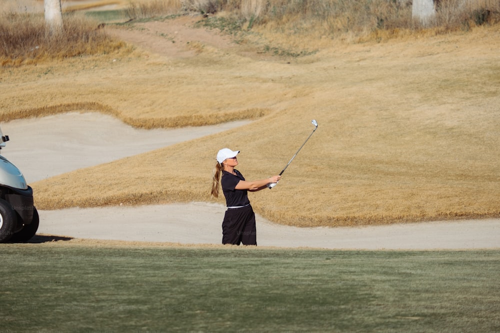 uma mulher que joga golfe em um campo de golfe