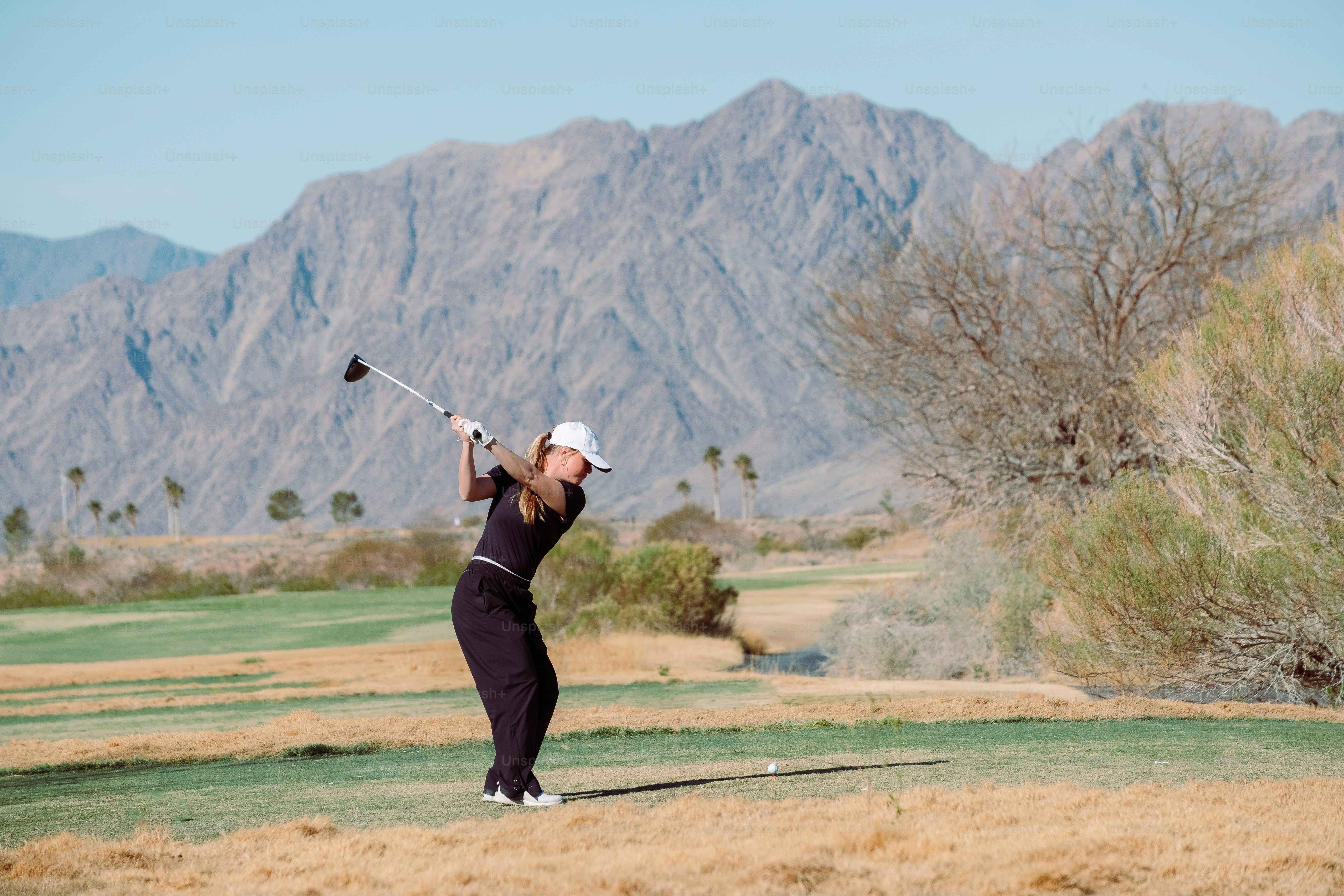 ゴルフ場でゴルフクラブを振る女性