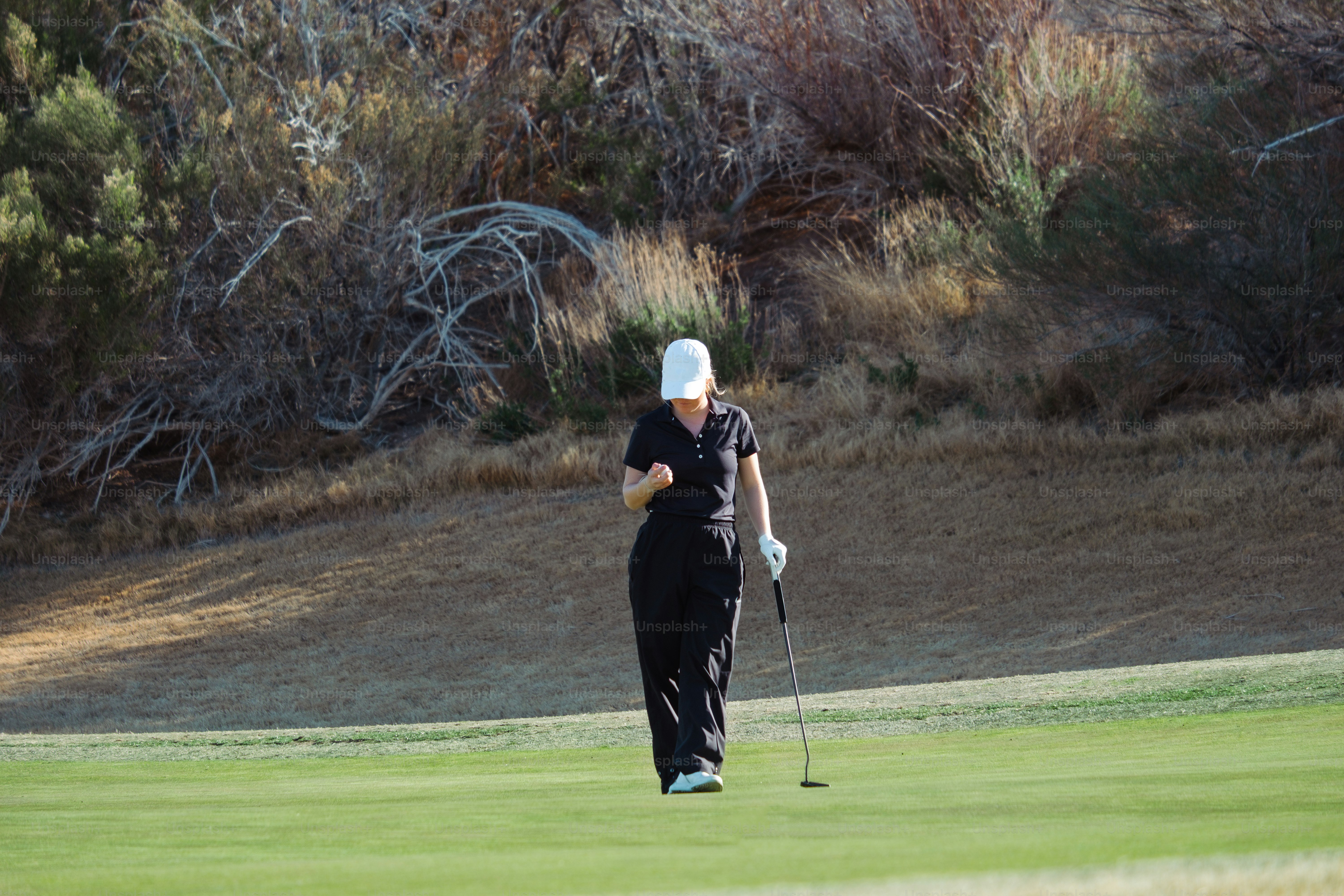 ゴルフクラブを持つゴルフコースの女性