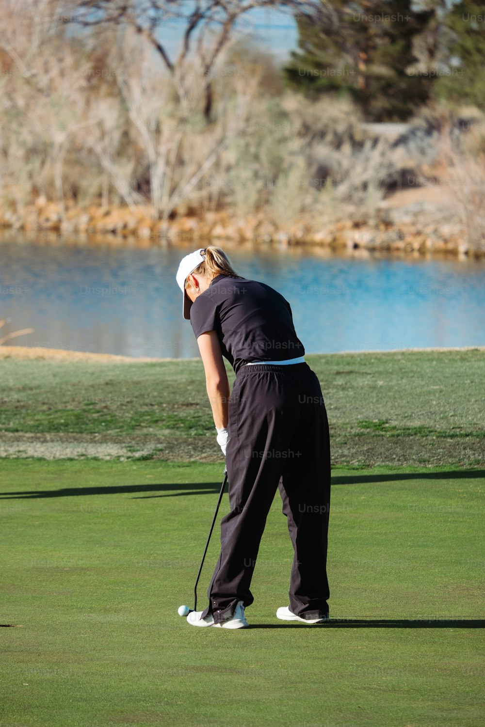Una mujer en un campo de golf sosteniendo un palo de golf
