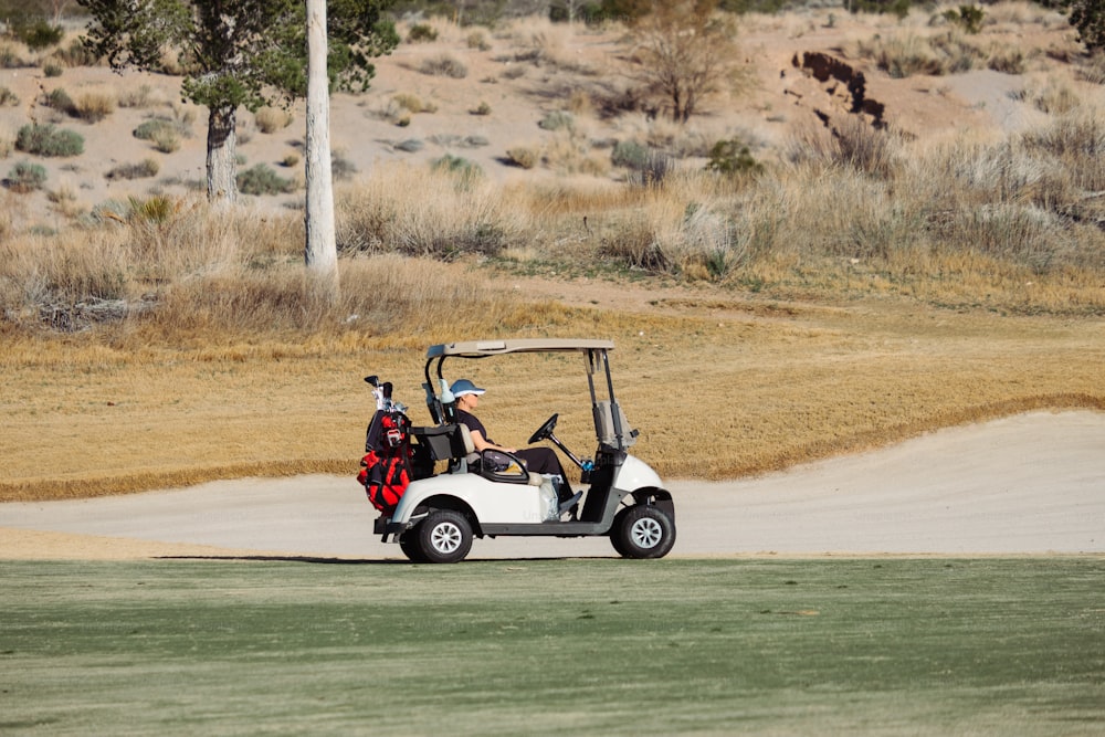 um homem que dirige um carrinho de golfe em um campo de golfe