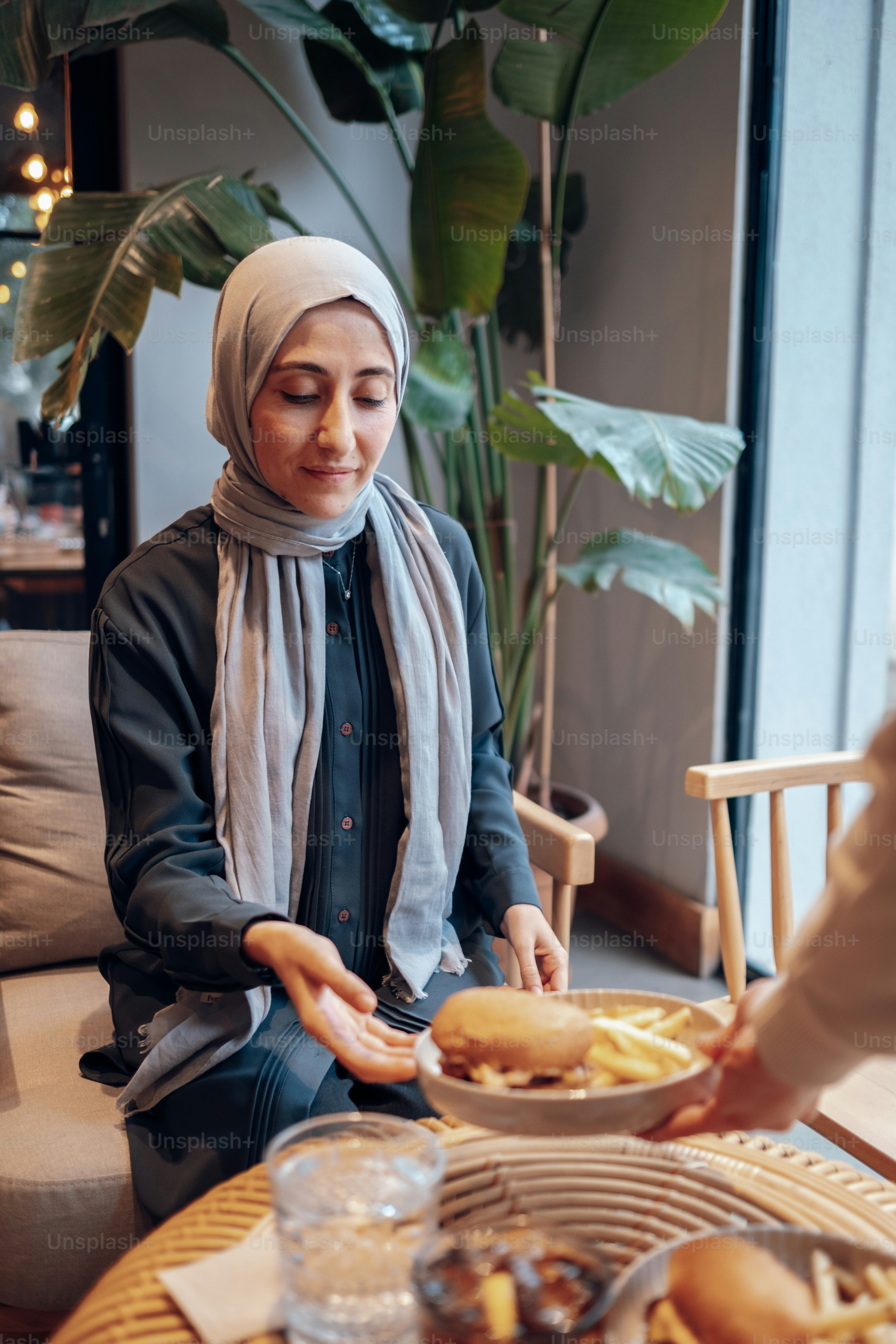 a woman sitting at a table with a plate of food