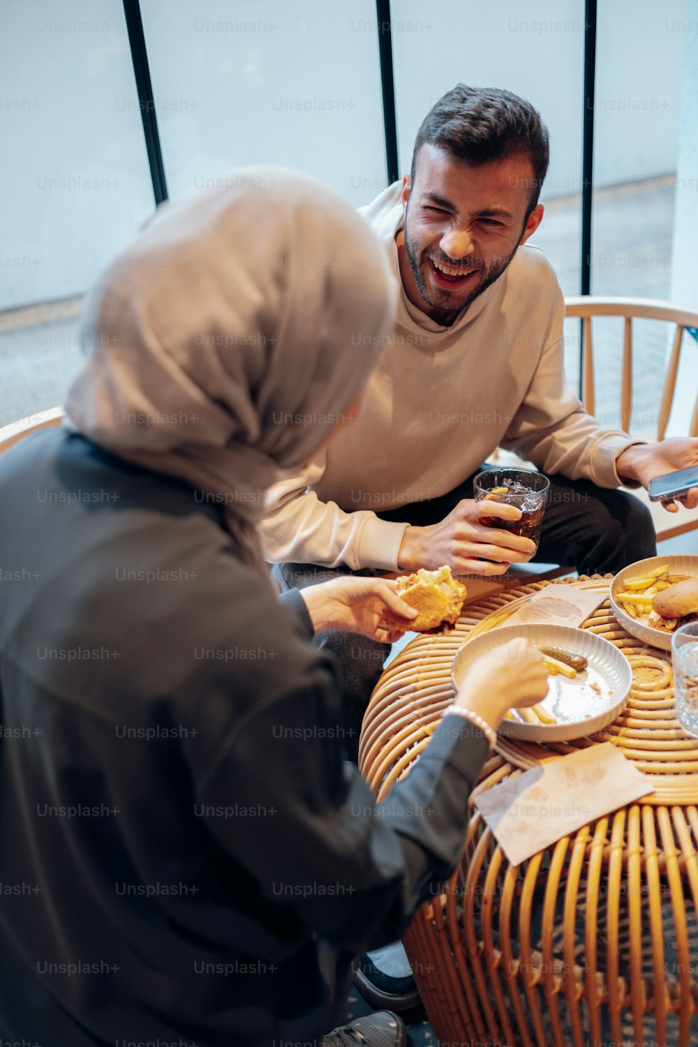 Un hombre y una mujer sentados en una mesa compartiendo una comida