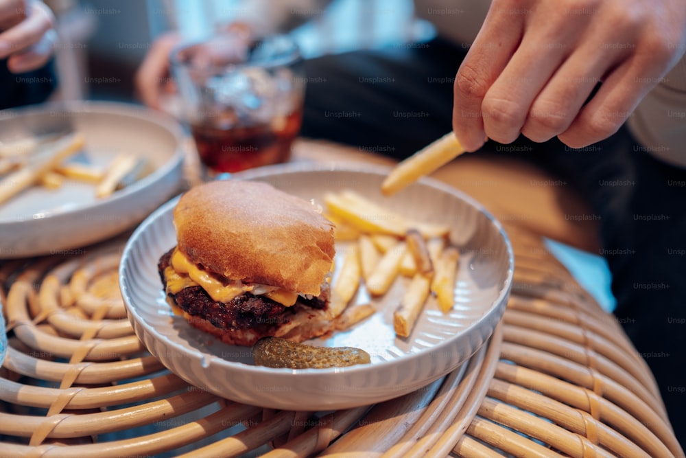 um hambúrguer e batatas fritas em um prato em uma mesa