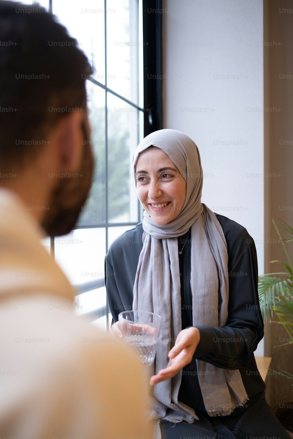 a woman in a hijab is talking to a man