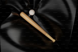 a baseball bat and a ball on a black cloth