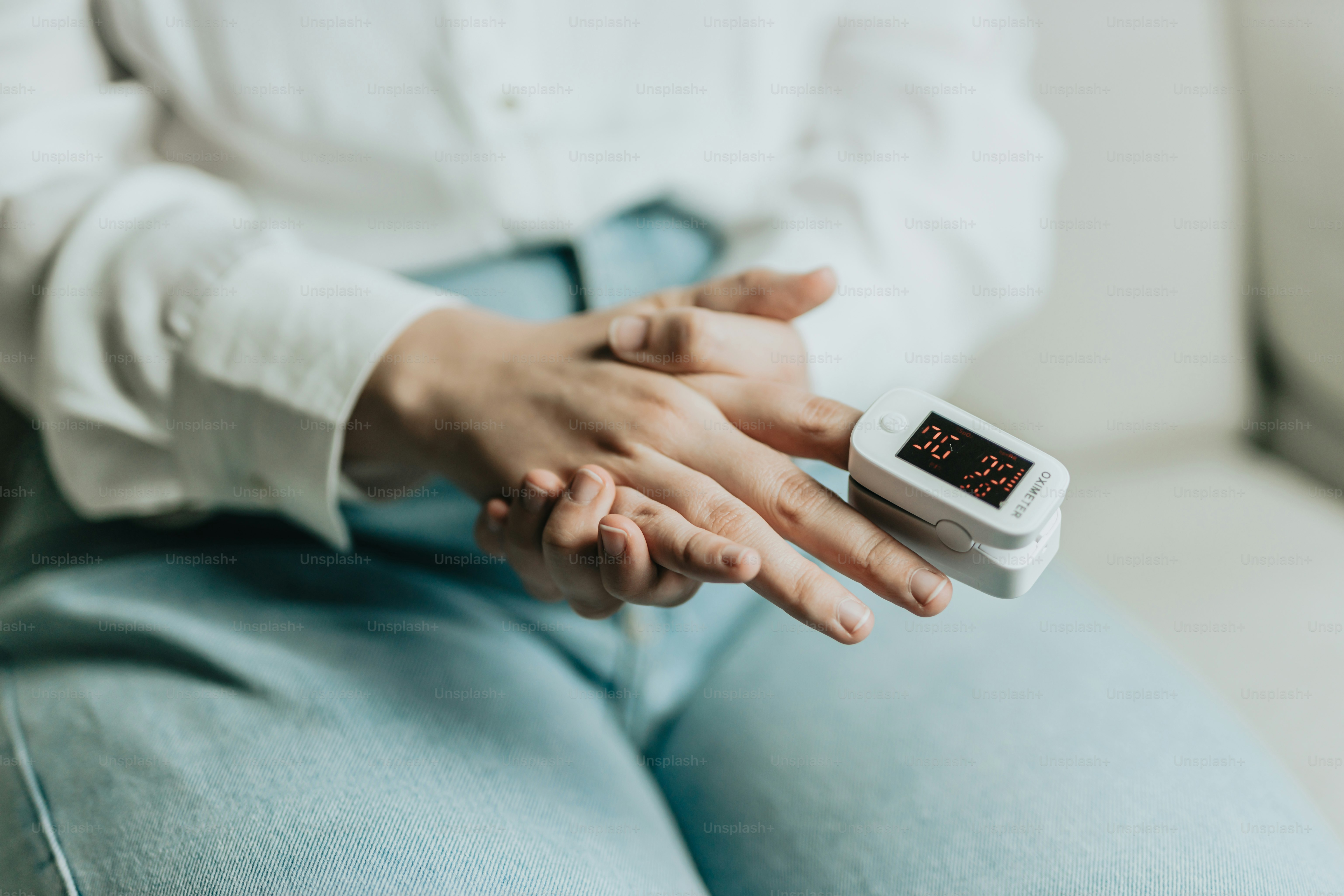 eine Person, die auf einer Couch sitzt und ein elektronisches Gerät hält