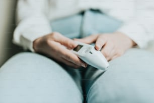 a person sitting on a couch holding a remote control