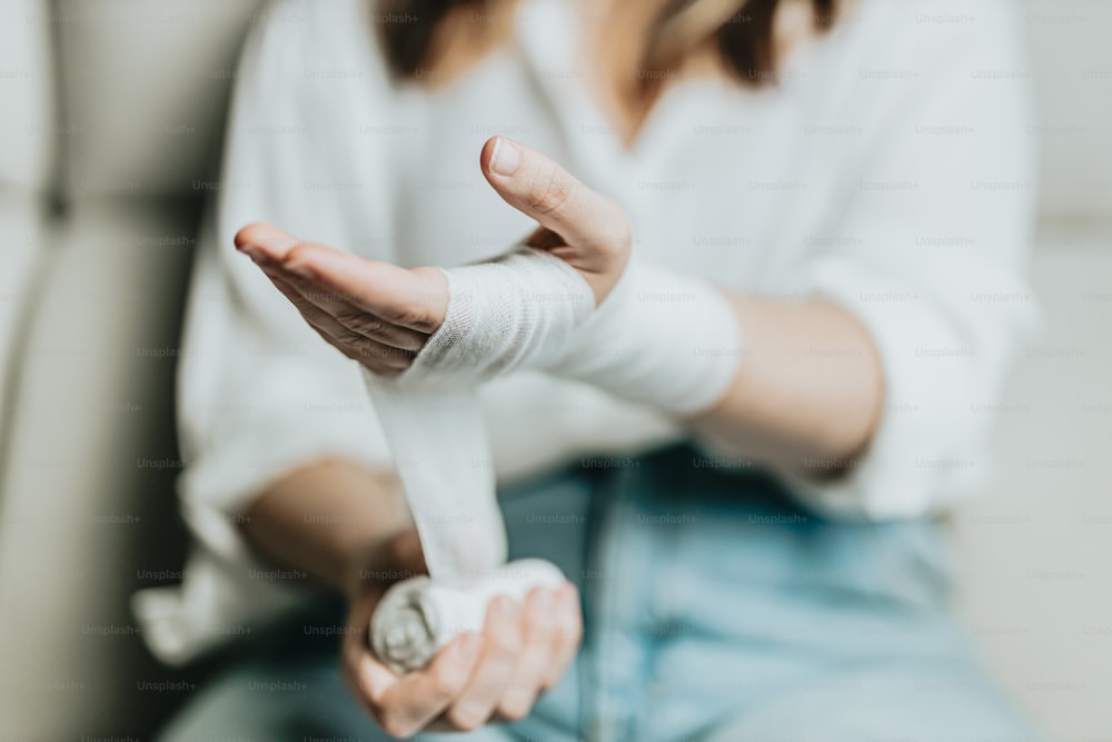 Eine Frau mit Gips am Arm sitzt auf einer Couch