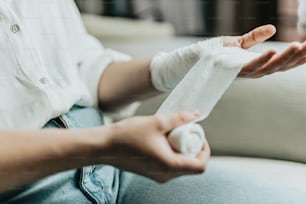 une personne assise sur un canapé avec un bandage à la main