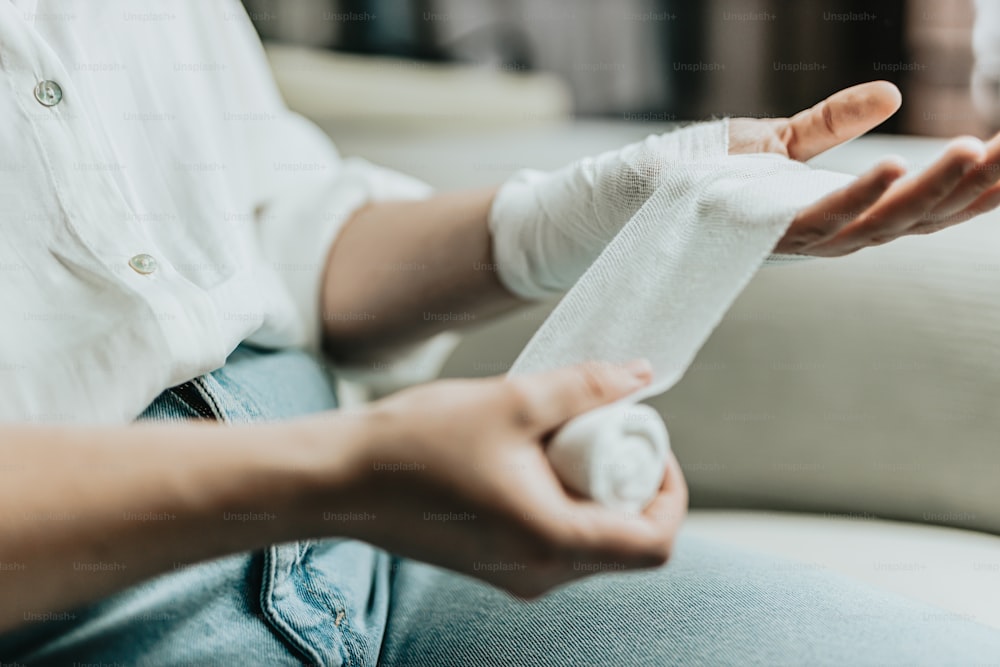 a person sitting on a couch with a bandage in their hand