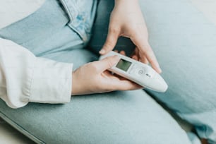 a person sitting on a couch holding a remote control