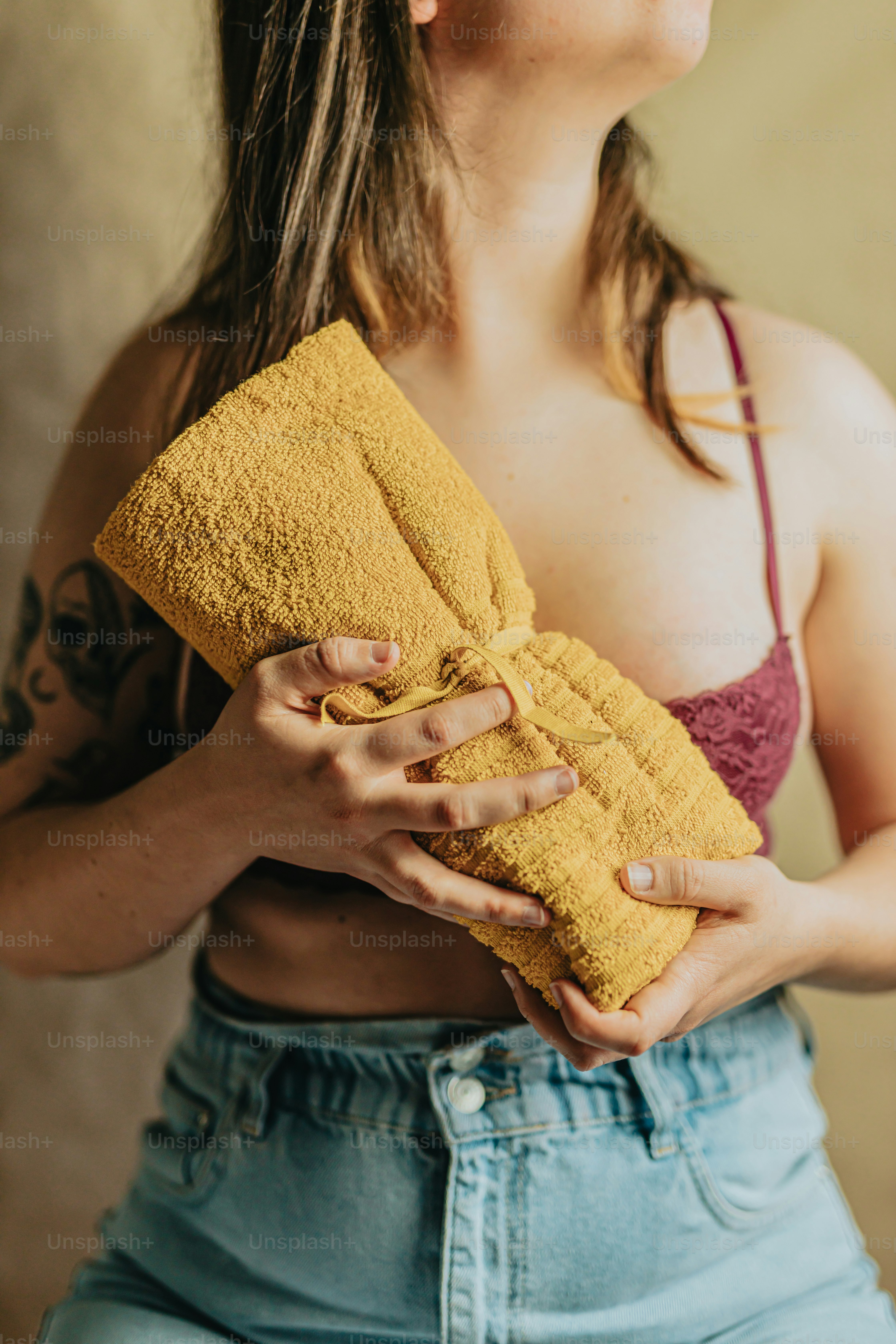 a woman holding a yellow towel in her hands