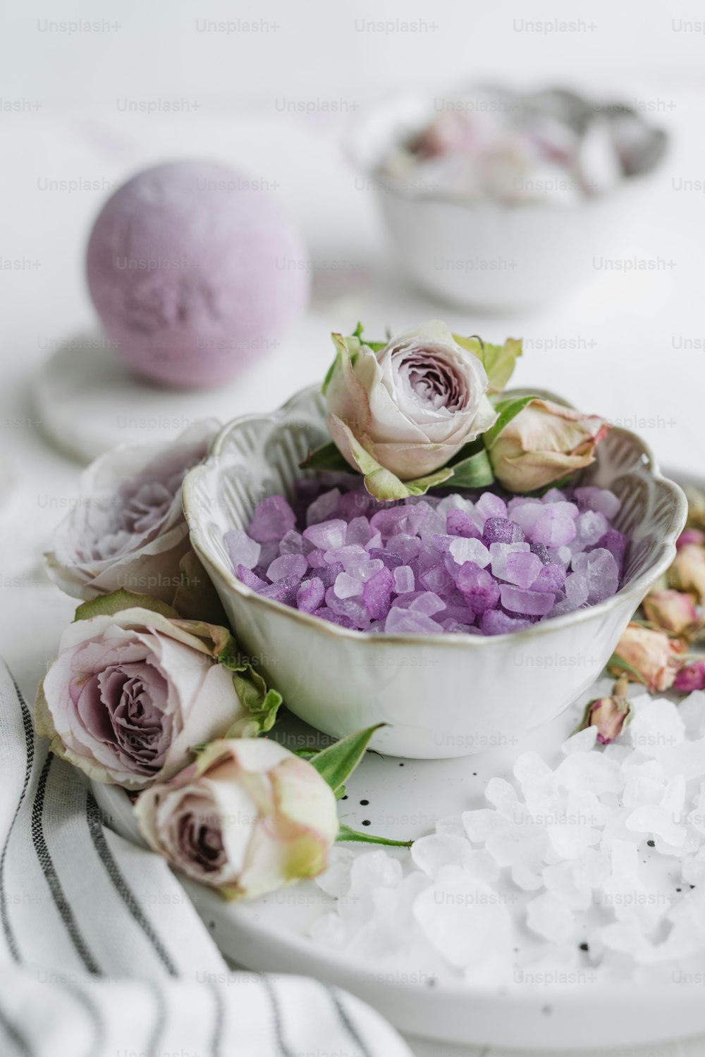 a white bowl filled with purple and white flowers
