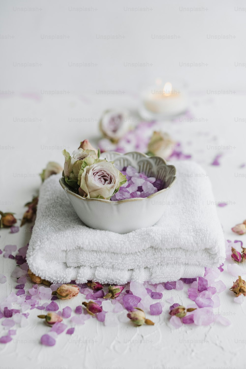 a bowl of flowers on a towel on a table