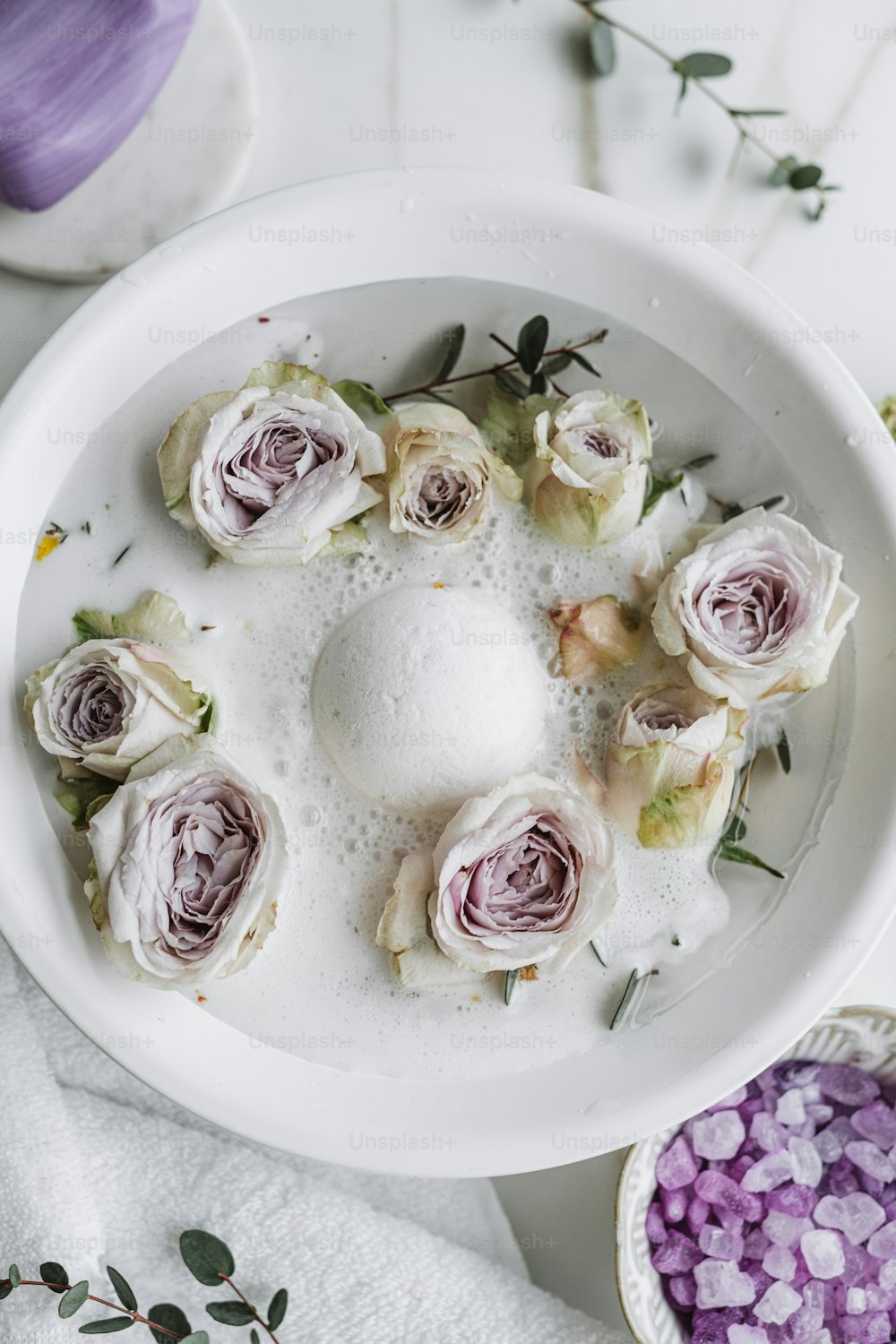 a white bowl filled with lots of white flowers