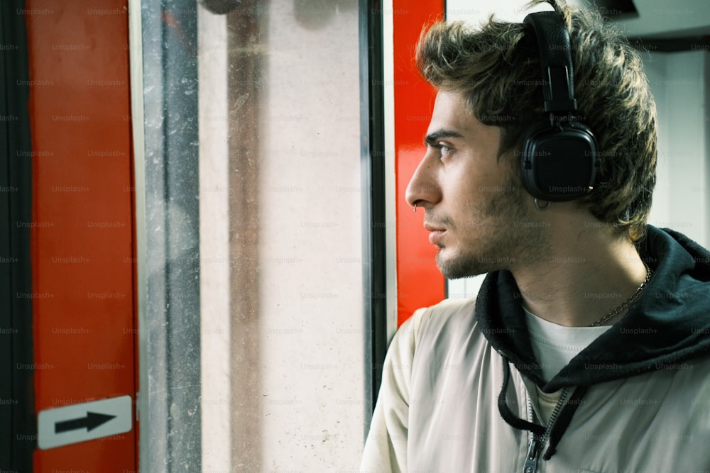 a man wearing headphones looking out a window