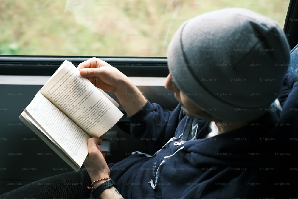 a person sitting in a car reading a book