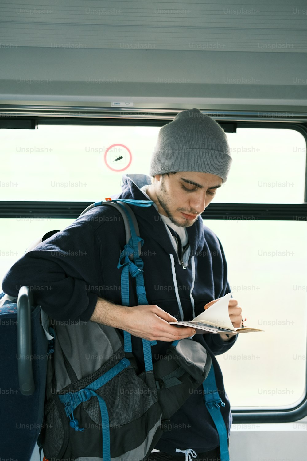 a man with a backpack is reading a book